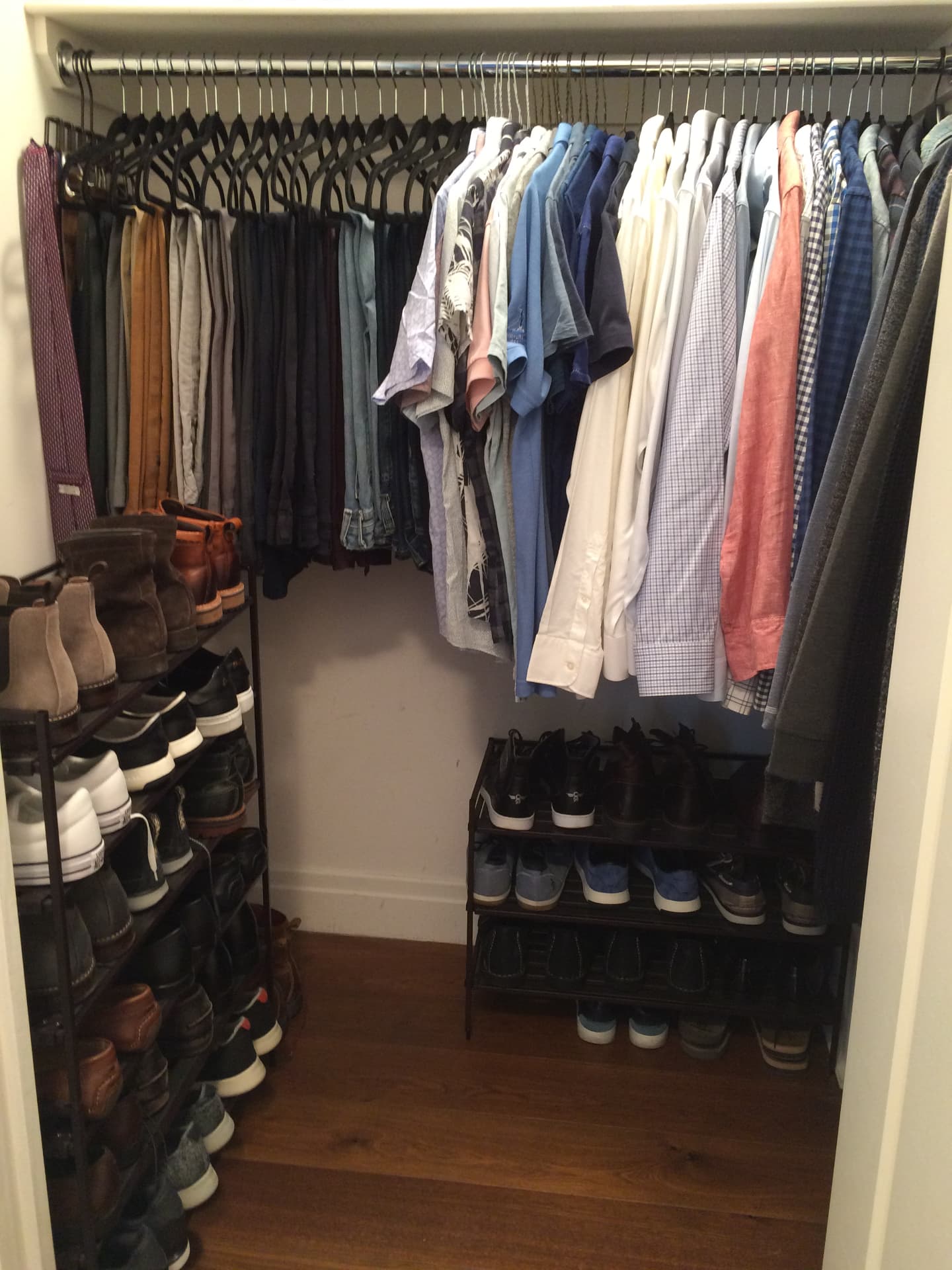 A tidy closet with shelves of folded clothes and rows of shoes