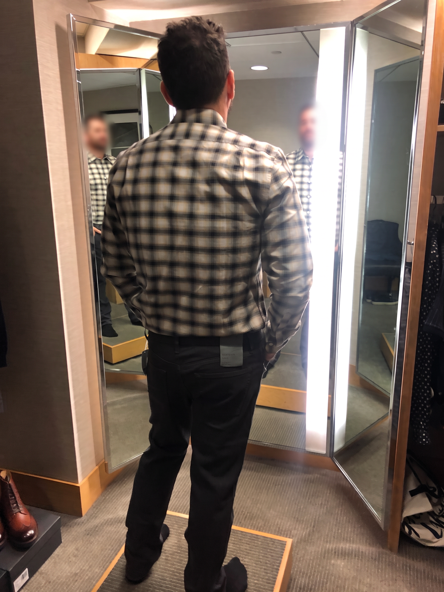 Checking the fit of a jacket in the fitting room mirror